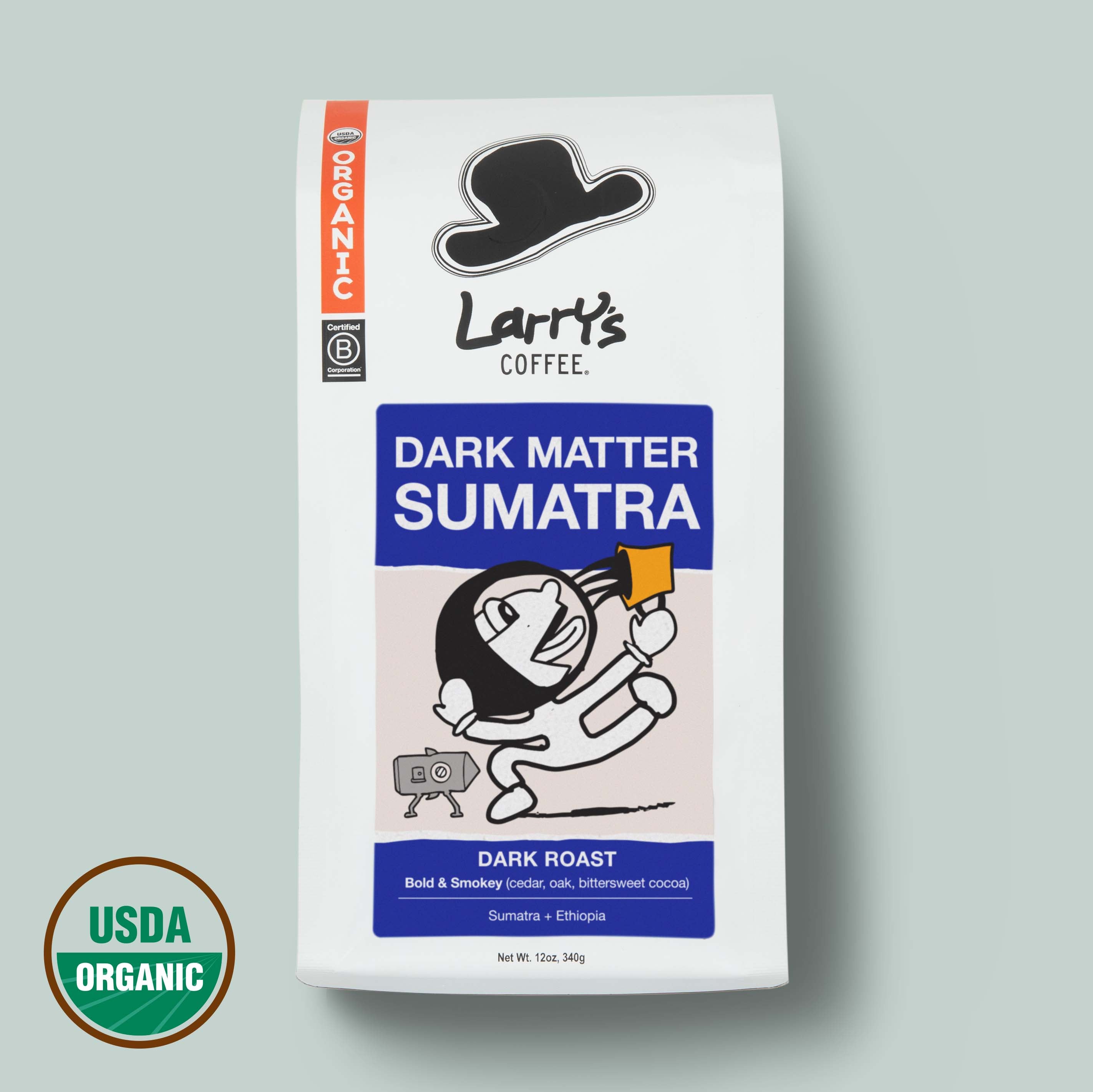 A bag of Larry's Coffee Dark Matter Sumatra dark roast coffee on a light gray background, featuring a white bag with blue and orange label blocks and a USDA Organic seal in the lower left corner.