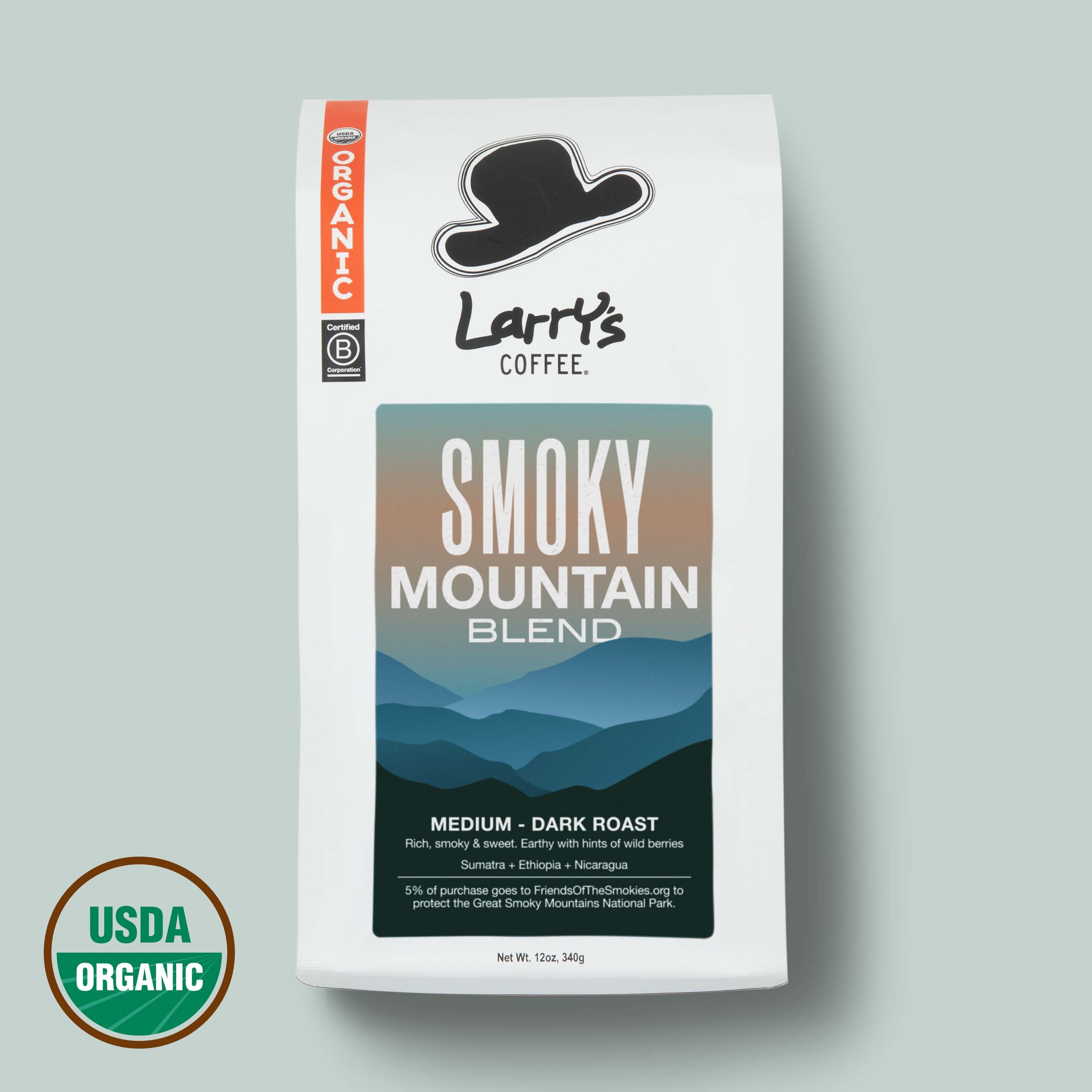 A bag of Larry's Coffee 'Smoky Mountain Blend' medium-dark roast coffee on a light gray background, featuring a USDA Organic seal in the bottom left corner.