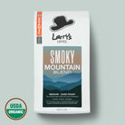 A bag of Larry's Coffee 'Smoky Mountain Blend' medium-dark roast coffee on a light gray background, featuring a USDA Organic seal in the bottom left corner.