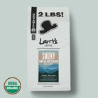 A 2 lb bag of Larry's Coffee Smokey Mountain Blend on a light sage green background, featuring a white bag with black text and a USDA Organic seal in the bottom left corner.