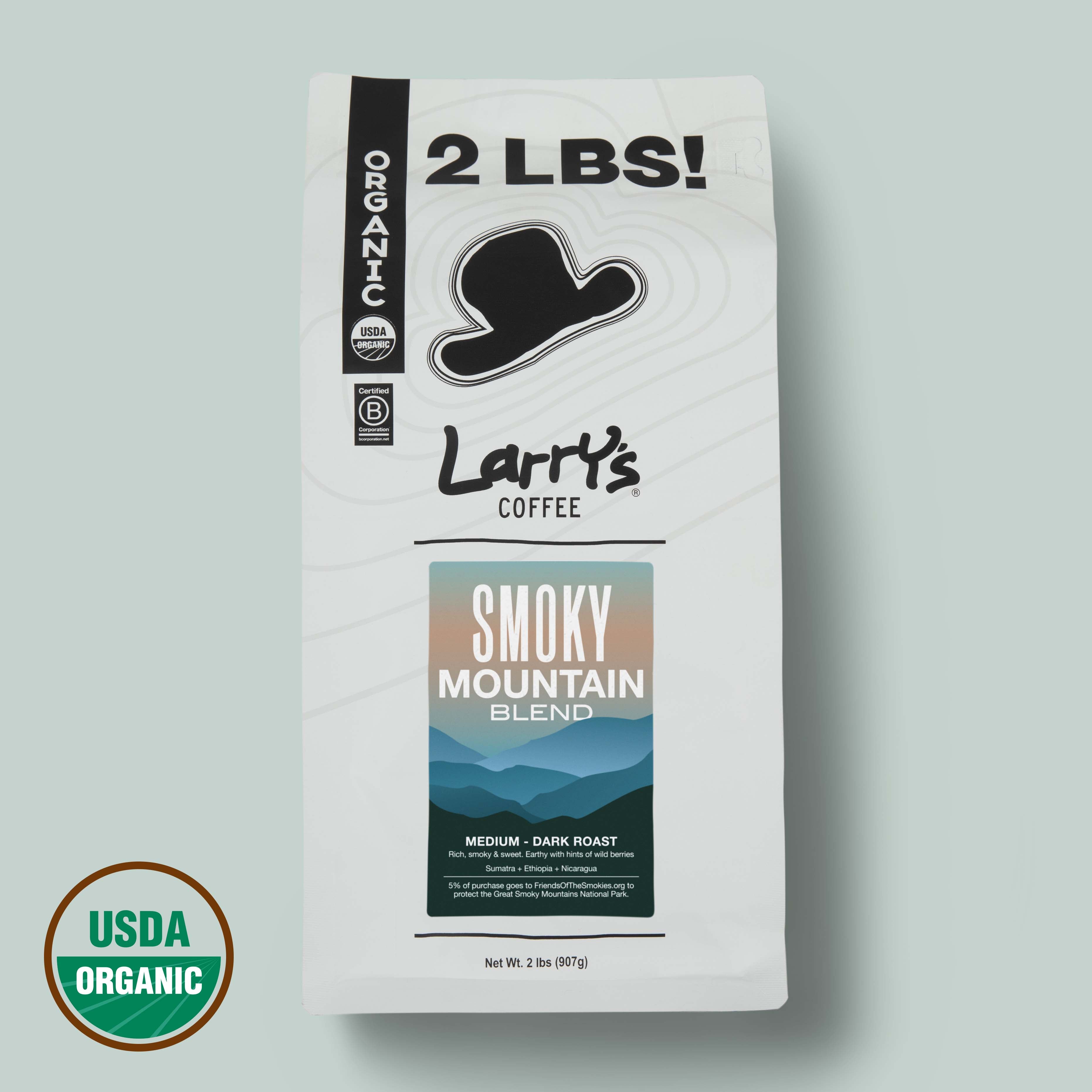 A 2 lb bag of Larry's Coffee Smokey Mountain Blend on a light sage green background, featuring a white bag with black text and a USDA Organic seal in the bottom left corner.