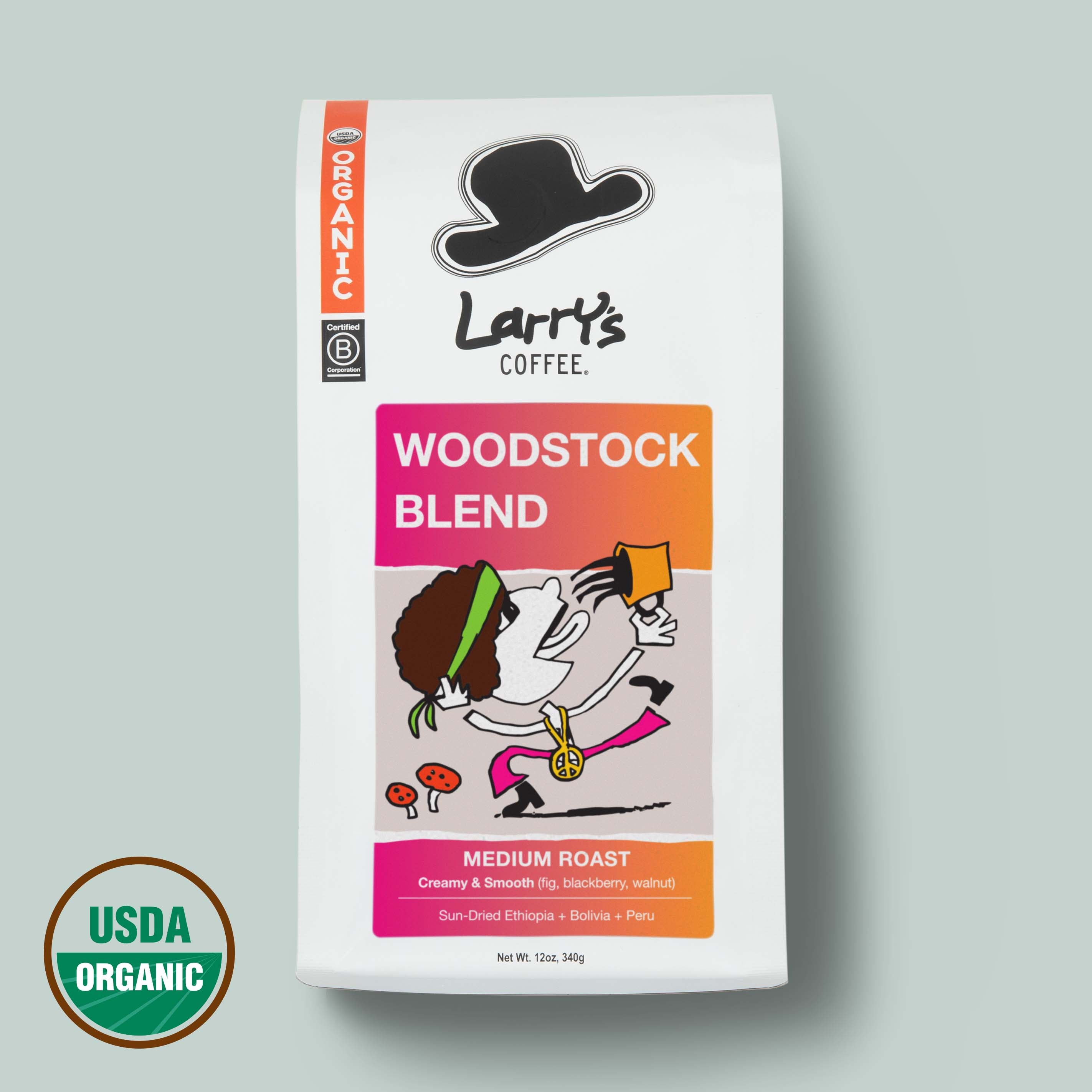 A bag of Larry's Coffee Woodstock Blend medium roast coffee on a light gray background, featuring a white bag with a colorful label and a USDA Organic seal in the lower left corner.